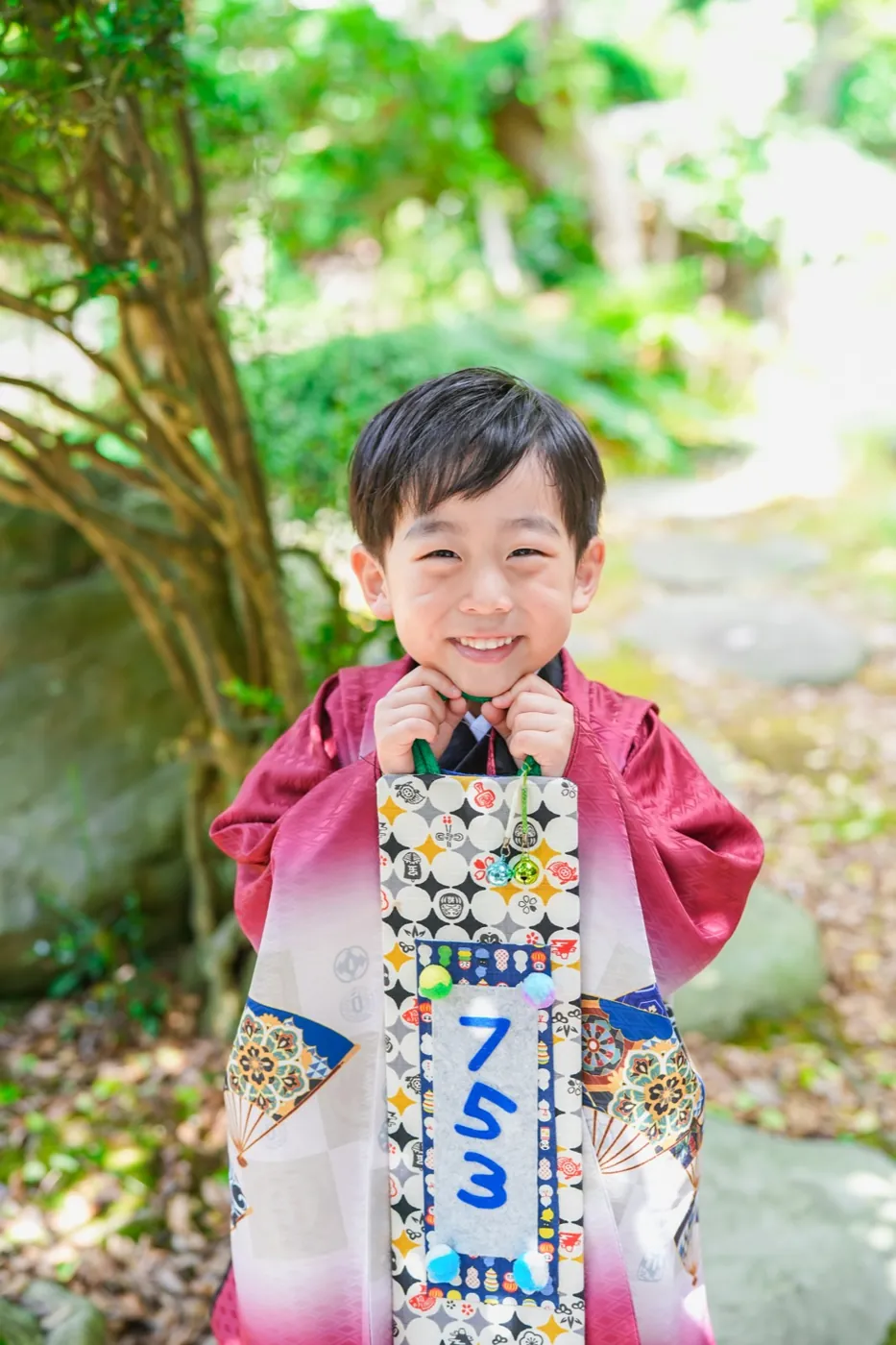 千歳飴を持って笑う5歳男の子の羽織袴姿