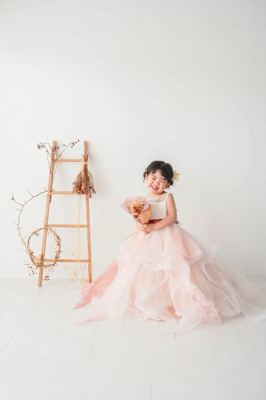 白いスタジオでピンクのドレスを着た女の子