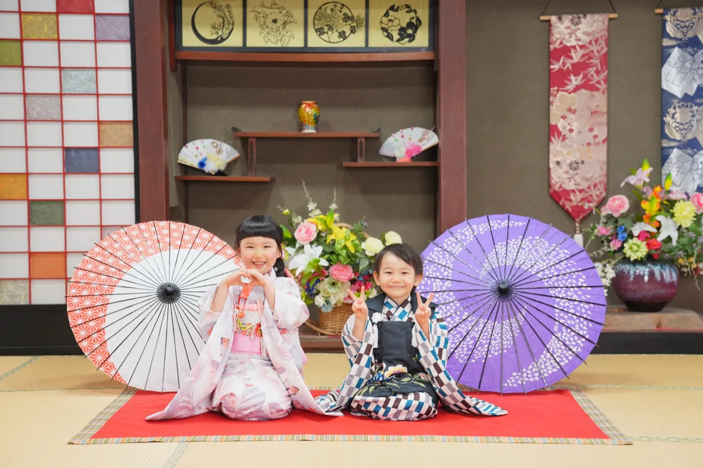 和傘の前に座る兄妹