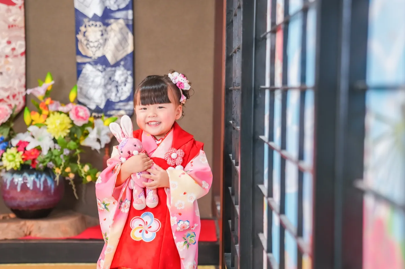 障子のそばでぬいぐるみを持つ3歳女の子