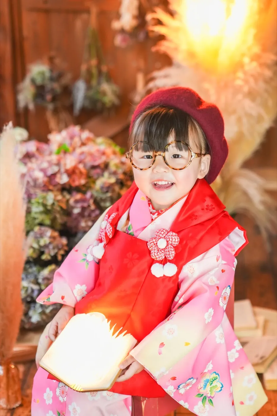 丸めがねで本を持つ3歳女の子