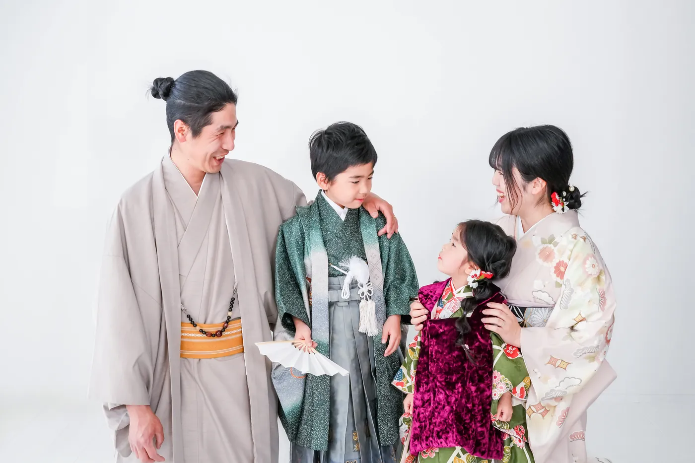 白いスタジオで笑い合う家族の七五三写真
