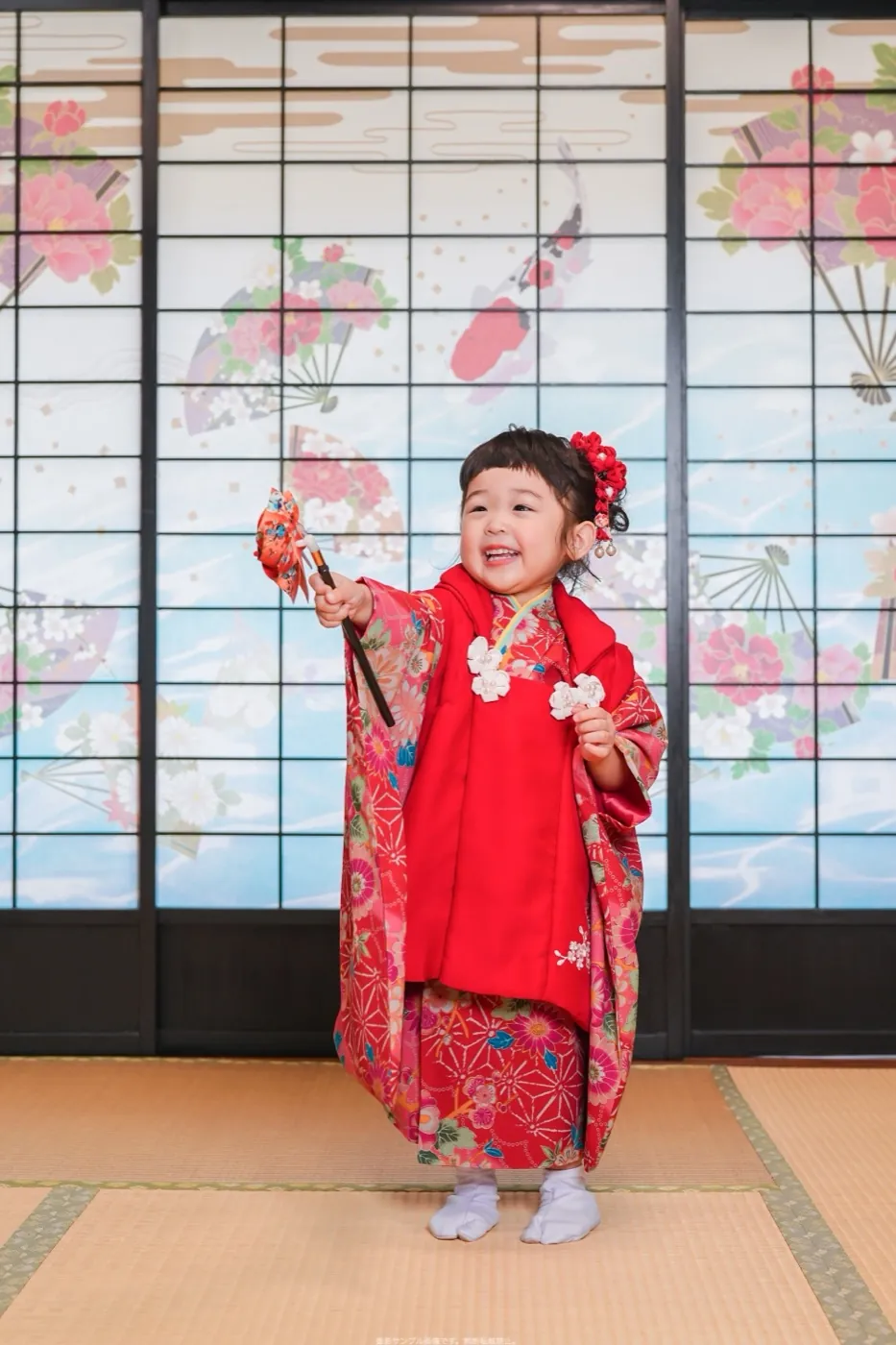 桜の障子の前で笑う3歳女の子