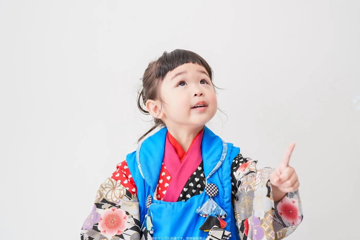 白いスタジオで上を見上げる女の子